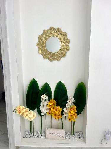 a shelf with flowers on it with a mirror at Dodi's house in Pozzuoli