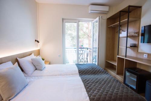 a hotel room with a bed and a balcony at Artelo - Inspired Stay in Bitola