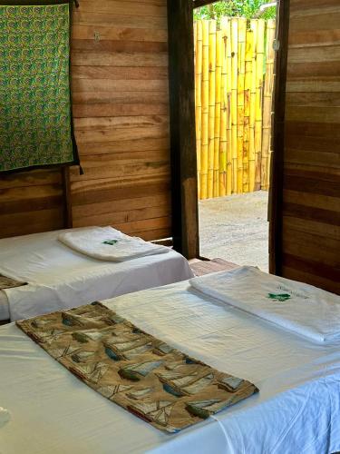two beds with towels on top of them in a room at Hibiscus House Nuquí in Nuquí