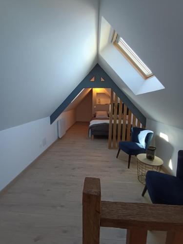 a attic room with a bed and a couch at Le Nid de la Baie in Pendé