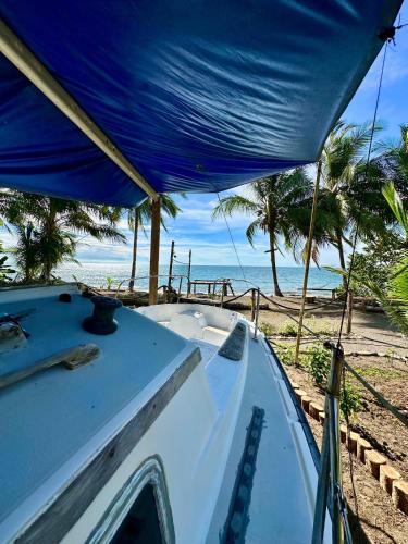 a boat sitting on the beach with a blue roof at Hibiscus House Nuquí in Nuquí