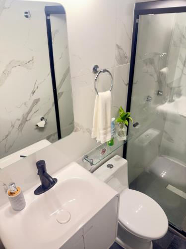 a white bathroom with a toilet and a sink at Apartamento Parota # in Sayulita