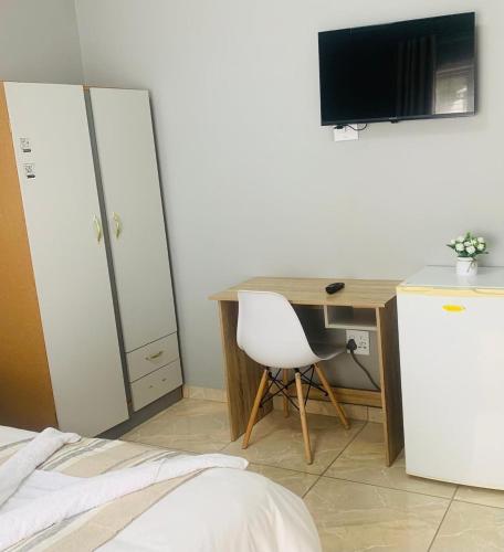 a bedroom with a desk with a computer and a bed at Maita Guest in Cape Town