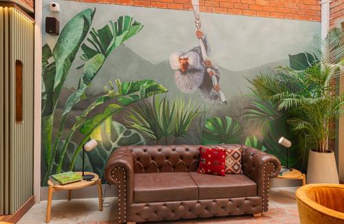 a couch in a room with a monkey mural at 5Q House Quinta Camacho in Bogotá