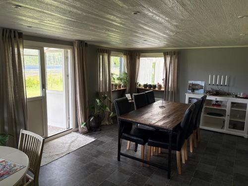 a dining room with a wooden table and chairs at Blomstergården in Vilshult