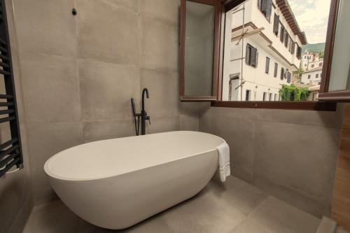 a white bath tub in a bathroom with a window at Balcon Makrinitsa in Makrinítsa