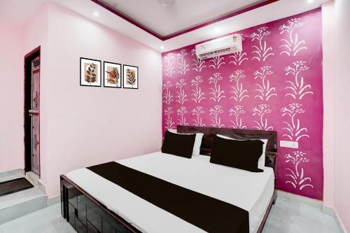 a bedroom with a bed with a purple wall at HOTEL O PRIME STAR in Lucknow