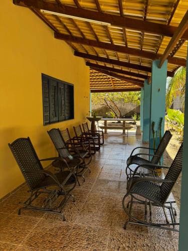 a row of chairs sitting on a patio at Casa de Veraneio in Caucaia