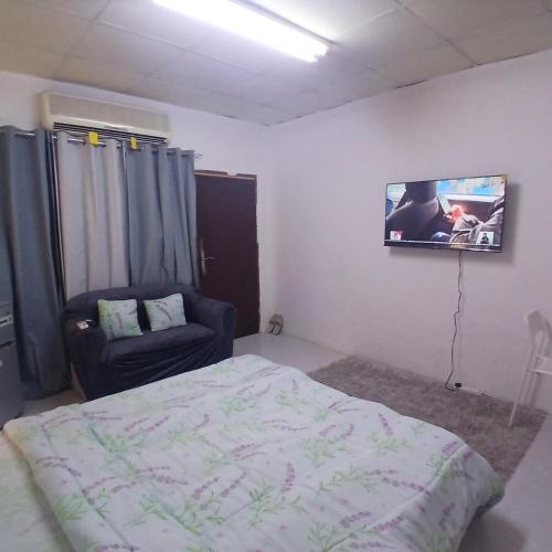 una camera da letto con un letto e una TV a parete di Al Ain Blue a Al Ain