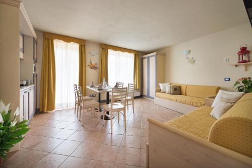 a living room with a couch and a table at Residence Adamello Resort in Ponte di Legno