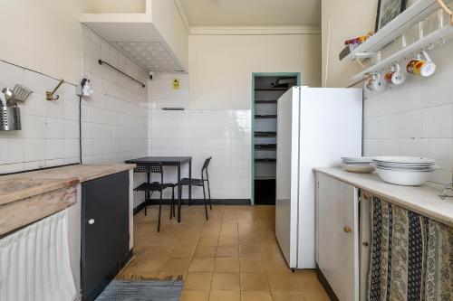 a kitchen with a refrigerator and a table at Liberdade Home Royal direito in Braga