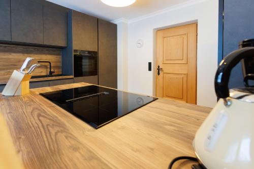 a kitchen with a counter with a black counter top at Ahorn Chalet in Mayrhofen