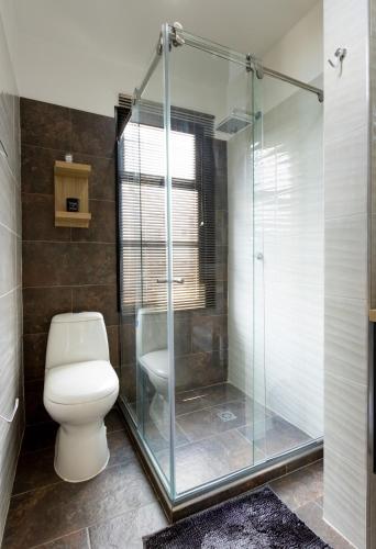 a bathroom with a toilet and a glass shower at Caobos Center Coliving & Coworking in Cúcuta