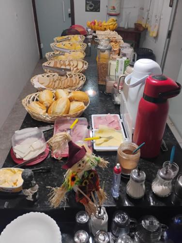 a counter with a bunch of plates of food at Pousada San Valen in Aparecida