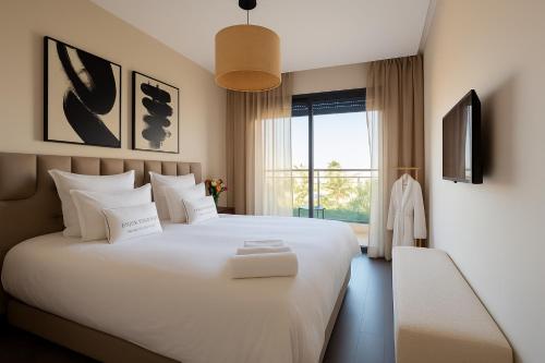 a bedroom with a large white bed and a window at Utopia Stays - Clair, Calme, Précis in Casablanca