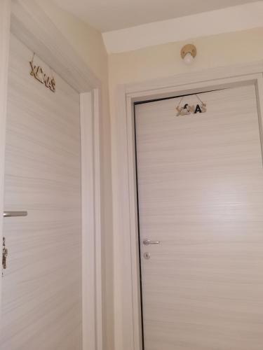 a white door with two bats on the wall at La Casa di Marta in Ateleta