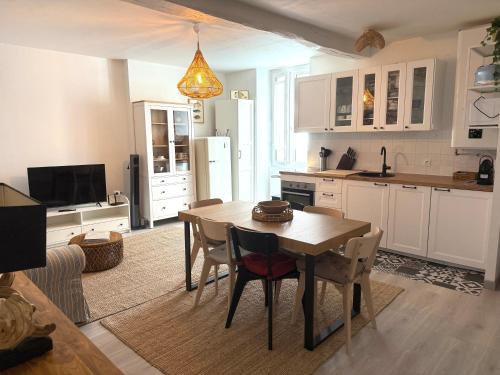 a kitchen with a wooden table and a dining room at La Belle Escale in Pauillac