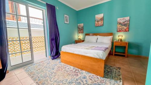 a bedroom with a bed with blue walls and a window at Poets Tavern & Inn in Avô