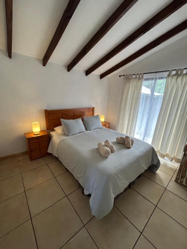 a bedroom with a bed with two stuffed animals on it at Mana Make Make in Hanga Roa