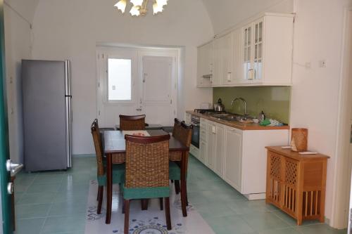a kitchen with a table and chairs and a refrigerator at Casa Flaùti Sorrento in Piano di Sorrento