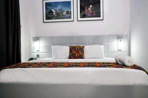 a bedroom with a large bed with two pictures on the wall at Chakaville Beach Resort in Iberekodo