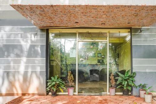 a patio with potted plants in front of a building at FabHotel Arambol Inn in Arambol