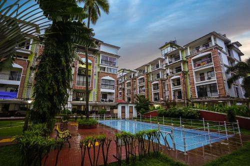 a group of apartment buildings with a swimming pool at Skylight BnB F203 - 2BHK with pool near Candolim beach in Candolim