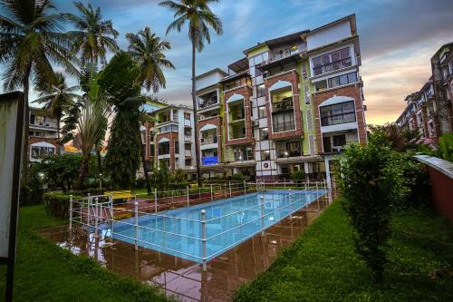 a swimming pool in front of some buildings at Skylight BnB F203 - 2BHK with pool near Candolim beach in Candolim
