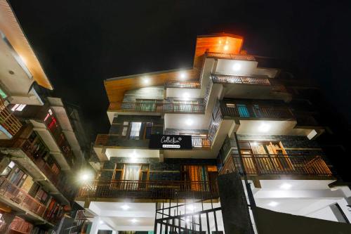 un edificio alto con balcones y luces. en Collection O Model Town Road, en Manali