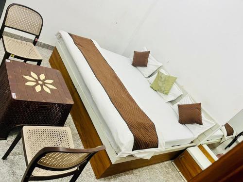 a bed with a table and chairs in a room at RADHIKA INn in Khātu