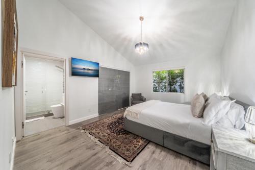 a white bedroom with a bed and a bathroom at Fulton Villa in Garnsey