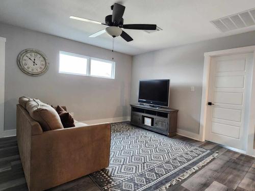 a living room with a couch and a tv and a clock at Modern Retreat in Sherman in Sherman