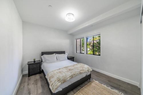 a white bedroom with a bed and a window at Fulton Villa in Garnsey