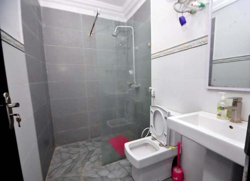 a bathroom with a shower and a toilet and a sink at Chakaville Beach Resort in Iberekodo