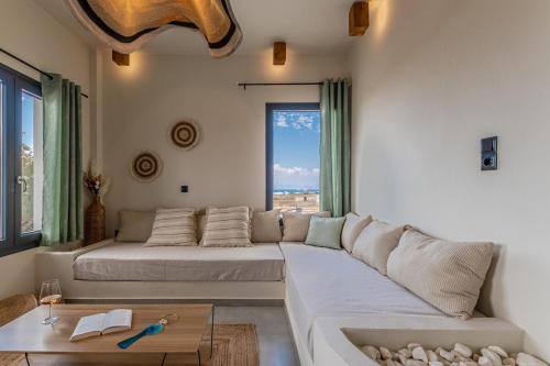 a living room with a white couch and a large window at Villa Eira, Luxury Retreat Kastraki Naxos in Kastraki Naxou