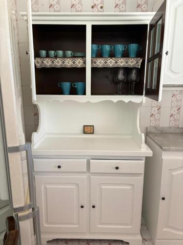 a white cabinet with blue dishes in it at Una Rotonda sul Mare in Formia