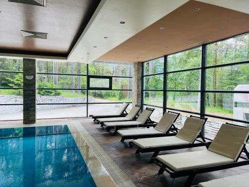 una piscina con sedie a sdraio e una piscina di Chamkoria Forest View & Spa Apartment a Borovets