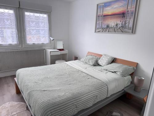 a bedroom with a bed and a painting on the wall at Séjour détente et confort au calme d une impasse in Garges-lès-Gonesse