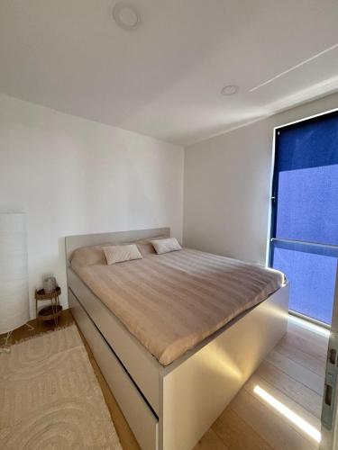 a bed in a room with a large window at Villa Stone House in Debeljaci