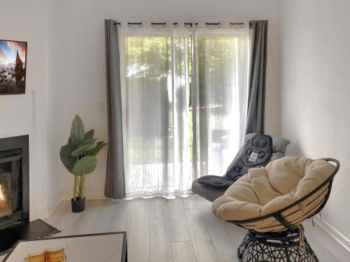 a living room with a chair and a large window at UNCW-Wrightsville Beach-Private Apartment in Wilmington