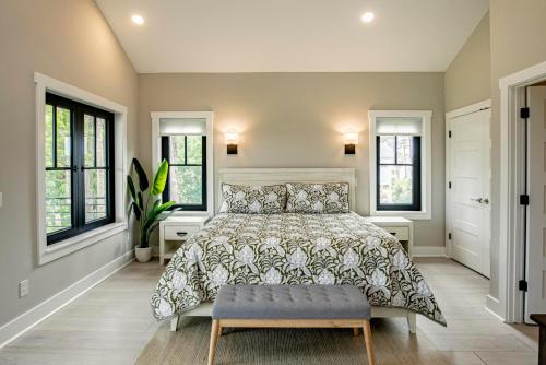 a bedroom with a large bed and windows at Experience Modern Coastal Living in this Beautifully Designed 4-Bed, 4-Bath Home in Fripp Island