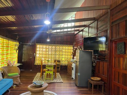 ein Wohnzimmer mit einem Tisch und einem Kühlschrank in der Unterkunft Casas Guaney, full furnished studios! in Manuel Antonio