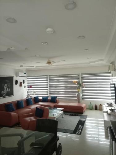 a living room with a red couch and blue pillows at Chakaville Beach Resort in Iberekodo
