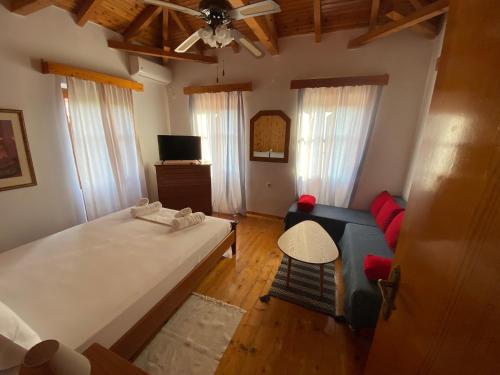 a bedroom with a large bed and a blue couch at Stavros Classic Appartment in Stoupa