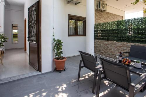 a patio with a table and chairs and a plant at Gennadi Sea Escape in Gennadi