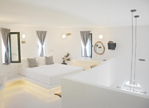 a white room with a bed and a bath tub at Renthousetinos 2 in Tinos