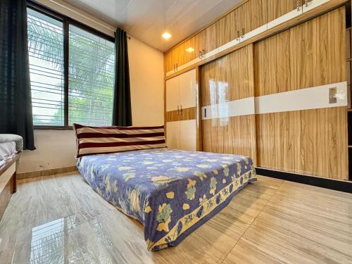 a bedroom with a bed and wooden walls at Zenstays Villa Igatpuri in Igatpuri