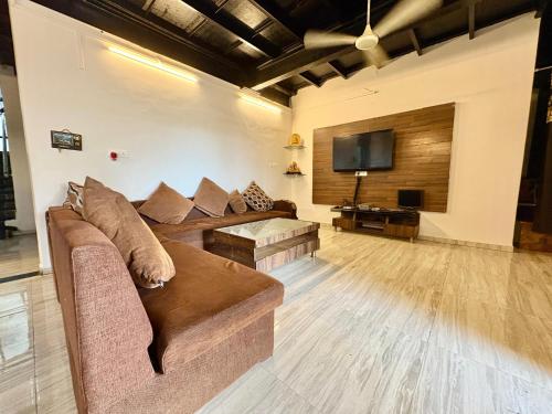 a living room with a couch and a flat screen tv at Zenstays Villa Igatpuri in Igatpuri