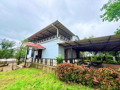 a small blue house with a fence in front of it at Zenstays Villa Igatpuri in Igatpuri