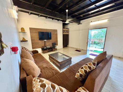 a living room with a couch and a tv at Zenstays Villa Igatpuri in Igatpuri